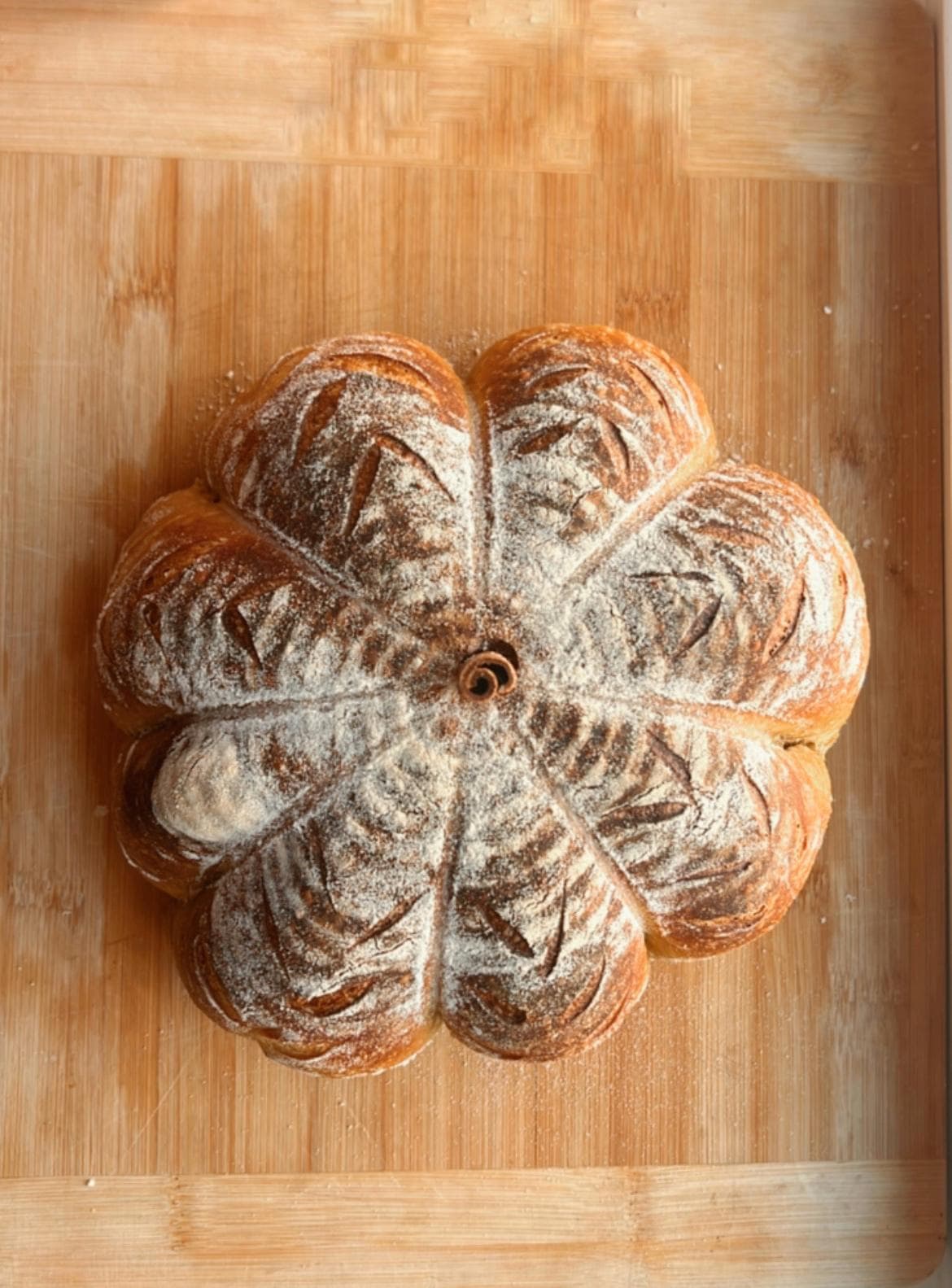 Flower-scored artisan sourdough loaf by The Morning Crumbs